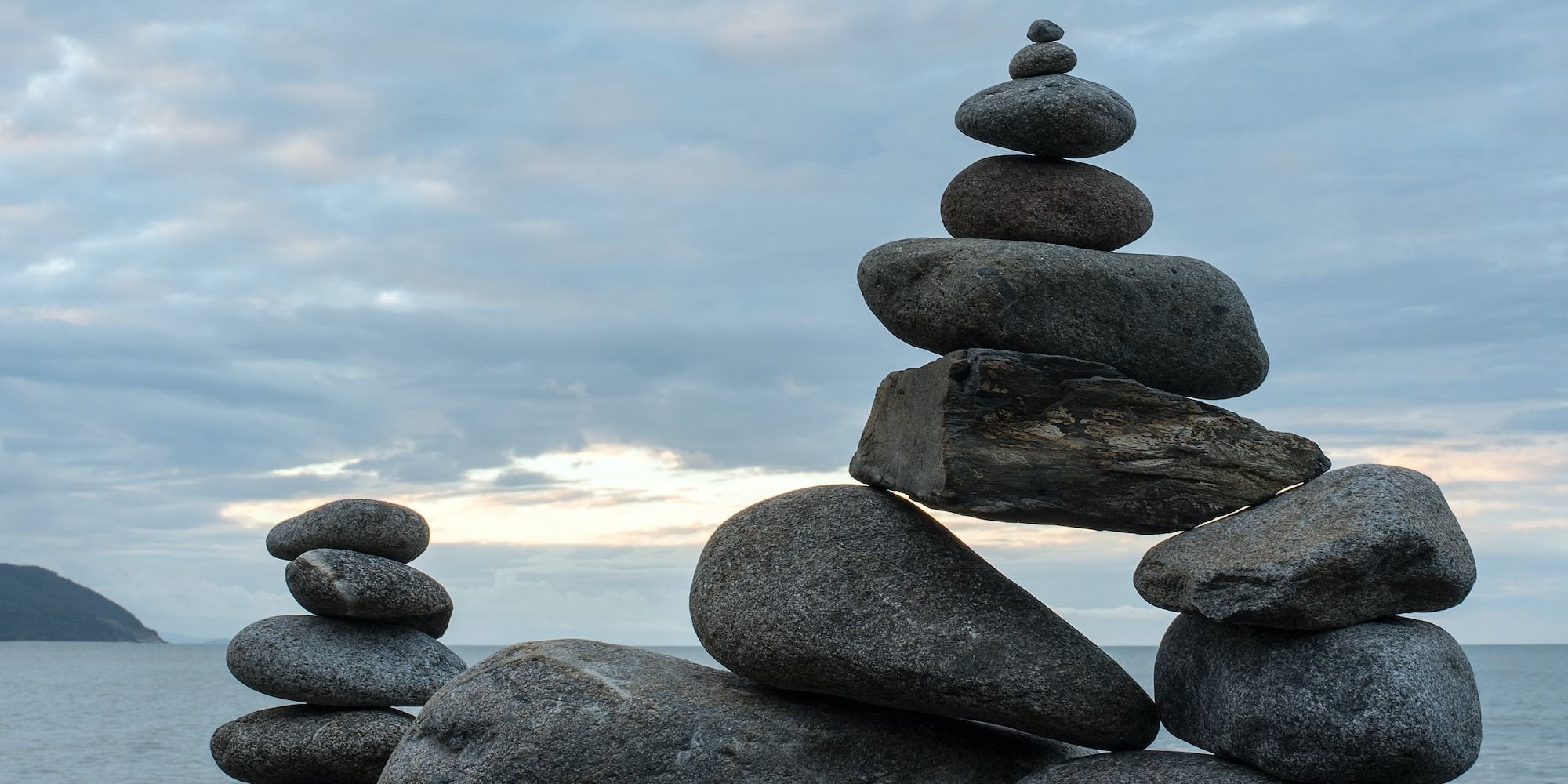 balanced stones on rock beside the ocean